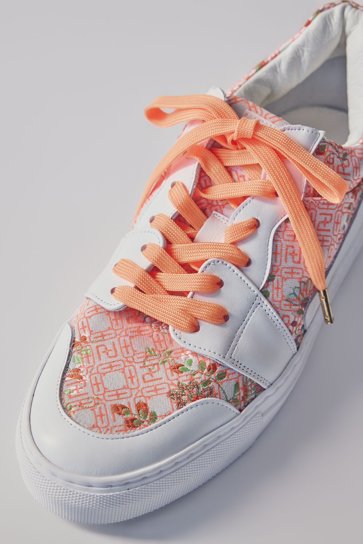 Low-cut sneakers with orange shoelaces